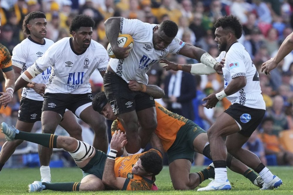 Fiji's Josua Tuisova, centre, pushes though Australia's defence during their rugby union international match in Newcastle, Australia, Sunday, July 6, 2025. (AP Photo/Mark Baker)