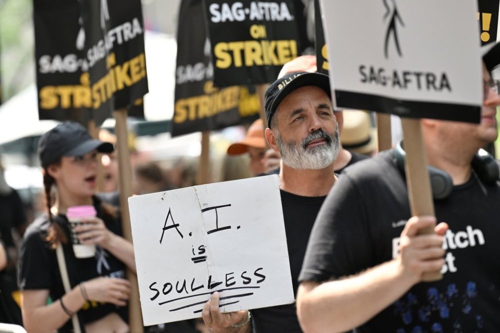 FILE - SAG-AFTRA picketers carry signs outside NBC in Rockefeller Center on July 17, 2023, in New York. (Photo by Evan Agostini/Invision/AP, File)