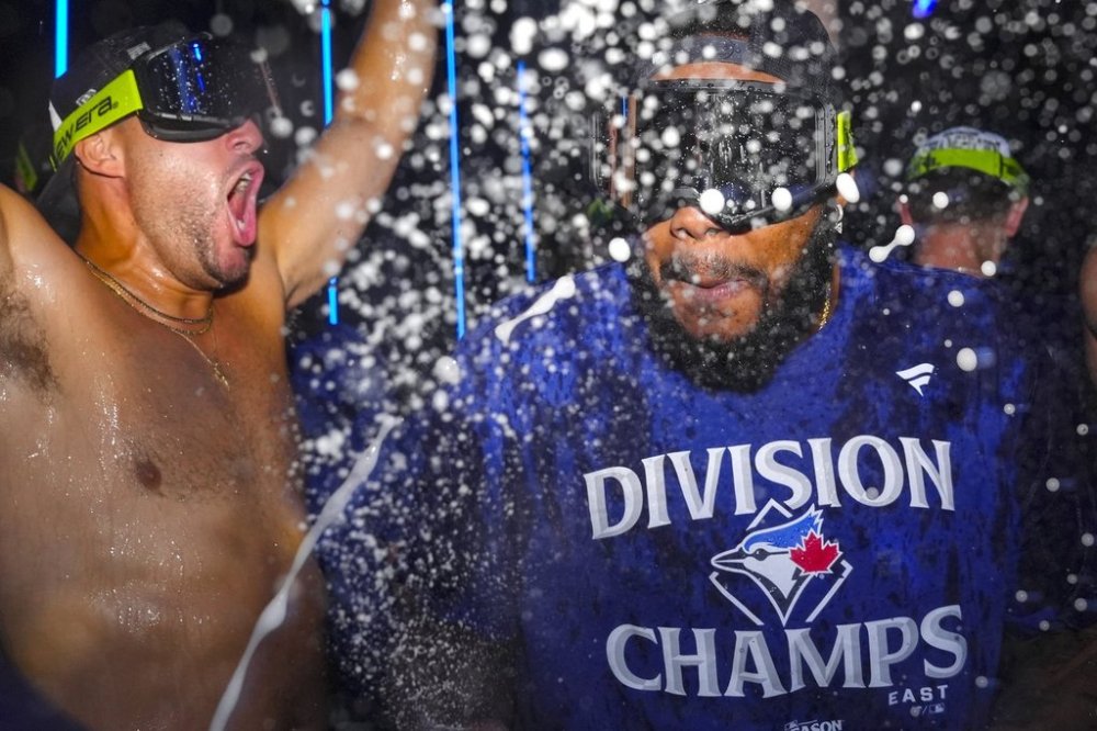 Blue Jays first baseman Vladimir Guerrero Jr. (right) and teammate George Springer celebrate after winning the American League East Division title at Rogers Centre in Toronto on Sept. 28, 2025. THE CANADIAN PRESS/Chris Young
