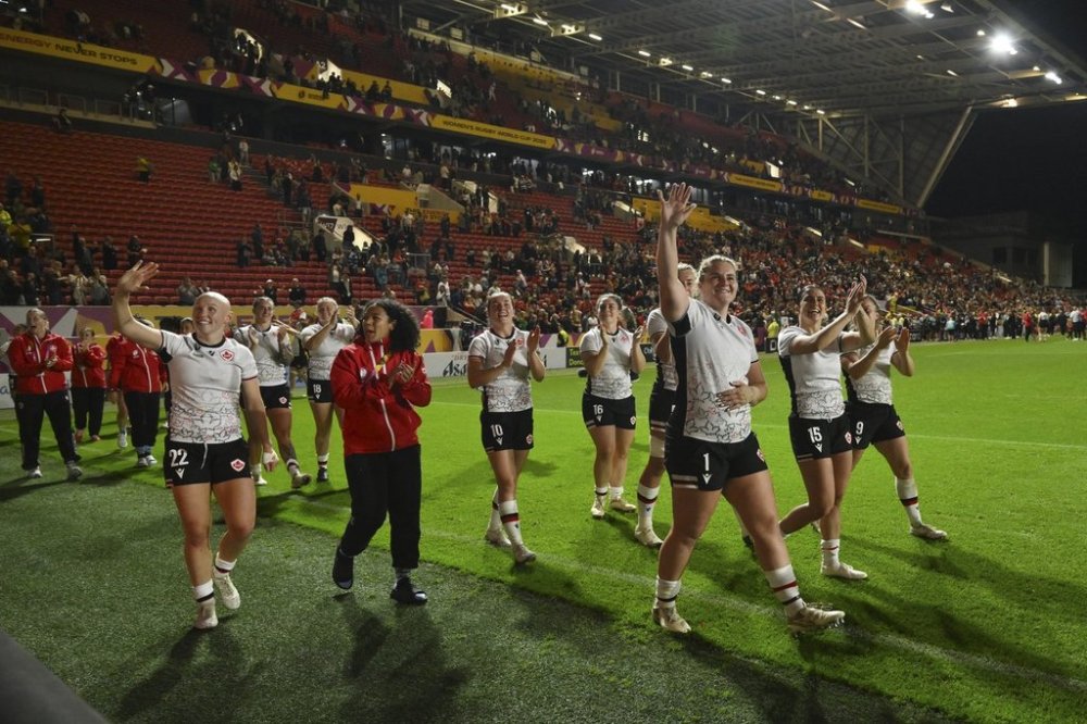 Canada's team players celebrate after winning the Women's Rugby World Cup 2025 semifinal match between New Zealand and Canada in Bristol, England, Friday, Sept. 19, 2025. (AP Photo/Anthony Upton)