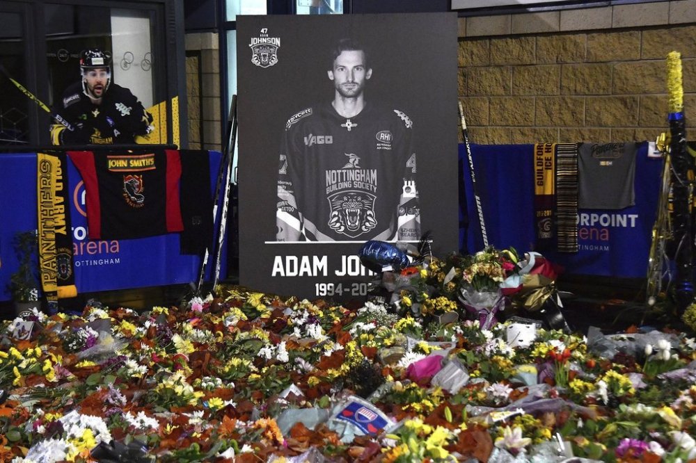 FILE - Floral tributes are placed for Nottingham Panthers player Adam Johnson, who died from a skate cut to the neck, outside the Motorpoint Arena, in Nottingham, England, on Nov. 18, 2023, before a memorial ice hockey game between the Panthers and the Manchester Storm. (AP Photo/Rui Vieira, File)