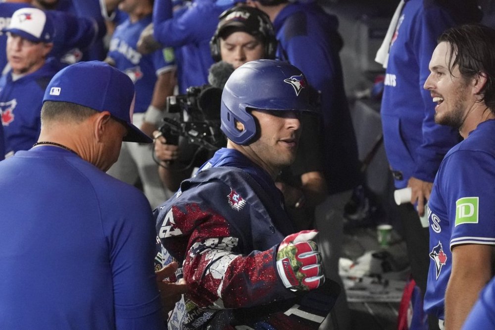 Blue Jays outfielder Daulton Varsho (5) celebrates in the dugout after hitting a grand slam off Boston Red Sox pitcher Justin Wilson during the sixth inning of a Major League Baseball game in Toronto on Sept. 25, 2025. THE CANADIAN PRESS/Chris Young