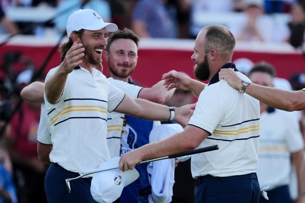Europe's Tyrrell Hatton celebrates with Tommy Fleetwood on the 18th hole during their singles match on the Bethpage Black golf course at the Ryder Cup golf tournament, Sunday, Sept. 28, 2025, in Farmingdale, N.Y. (AP Photo/Matt Slocum)
