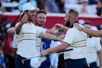 Europe's Tyrrell Hatton celebrates with Tommy Fleetwood on the 18th hole during their singles match on the Bethpage Black golf course at the Ryder Cup golf tournament, Sunday, Sept. 28, 2025, in Farmingdale, N.Y. (AP Photo/Matt Slocum)