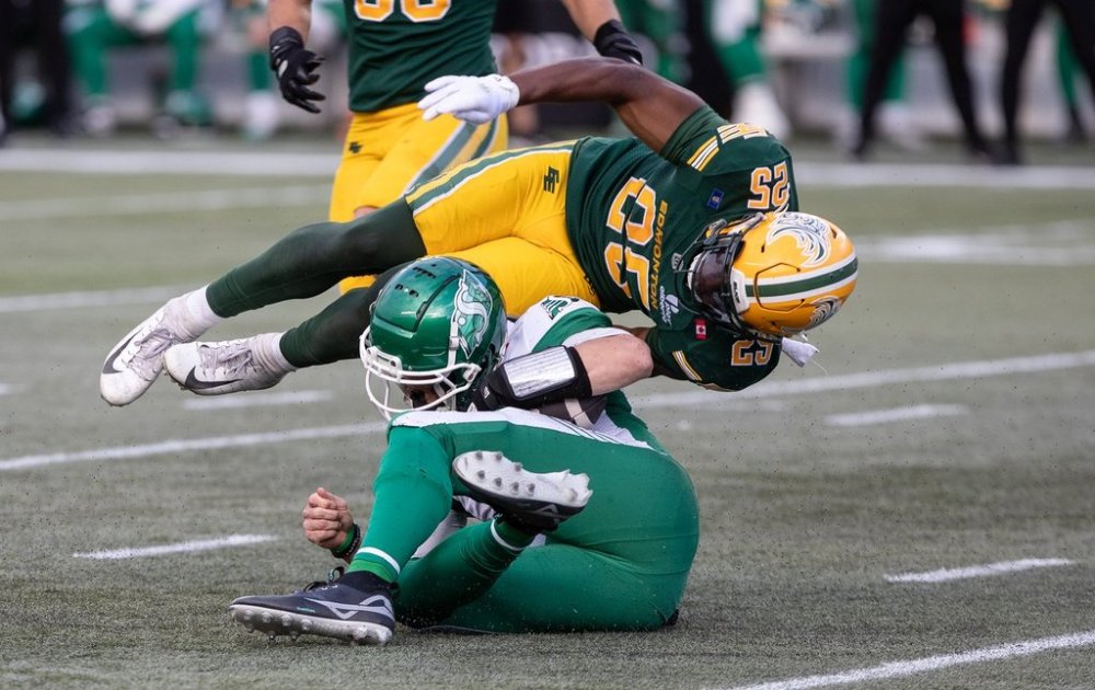 Saskatchewan Roughriders quarterback Trevor Harris (7) is tackled by Edmonton Elks' Chelen Garnes (25) during first half CFL action in Edmonton, on Saturday Sept. 27, 2025. THE CANADIAN PRESS/Jason Franson
