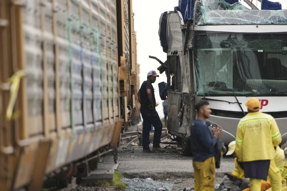 A man stands next to a bus that was hit by a freight train in Atlacomulco, Mexico, Monday, Sept. 8, 2025. (AP Photo/Fernando Llano)