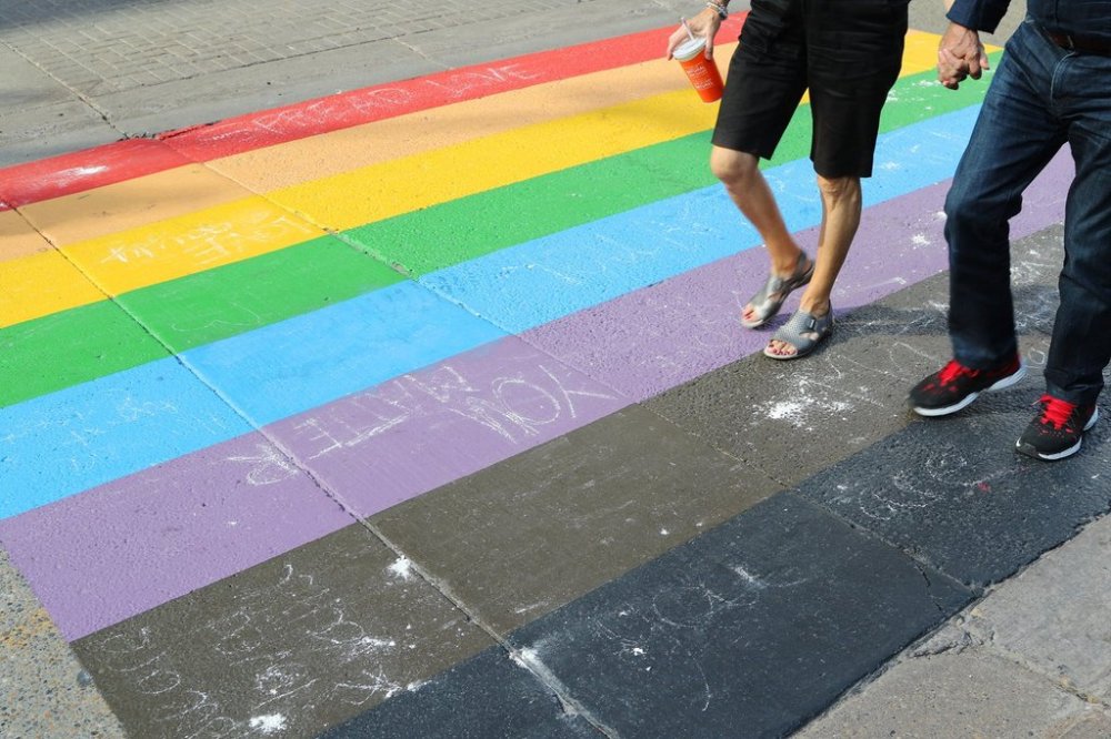 People walk on a Pride flag crosswalk in Calgary on Sunday, Aug. 18, 2019. THE CANADIAN PRESS/Dave Chidley