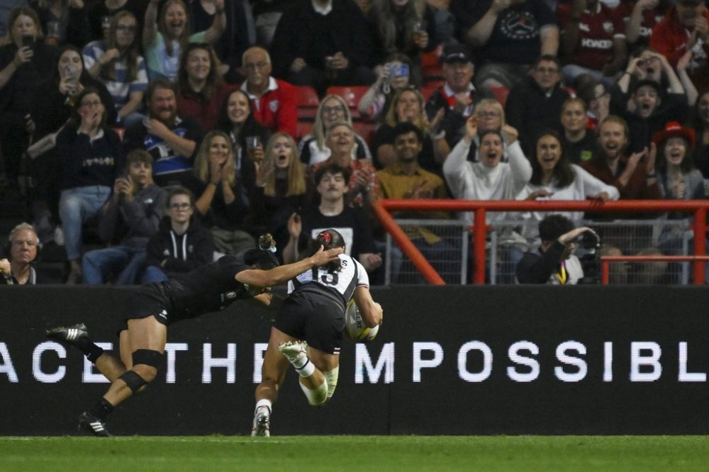 Canada's Florence Symonds, right, scores a try during the Women's Rugby World Cup 2025 semifinal match between New Zealand and Canada in Bristol, England on Friday, Sept. 19, 2025.(AP Photo/Anthony Upton)