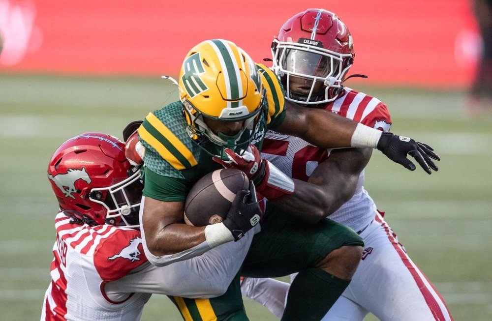 Calgary Stampeders' Damon Webb (9) and Shaun Peterson Jr. (58) tackle Edmonton Elks' Justin Rankin (5) during second half CFL action in Edmonton, Saturday, Sept. 6, 2025. THE CANADIAN PRESS/Jason Franson