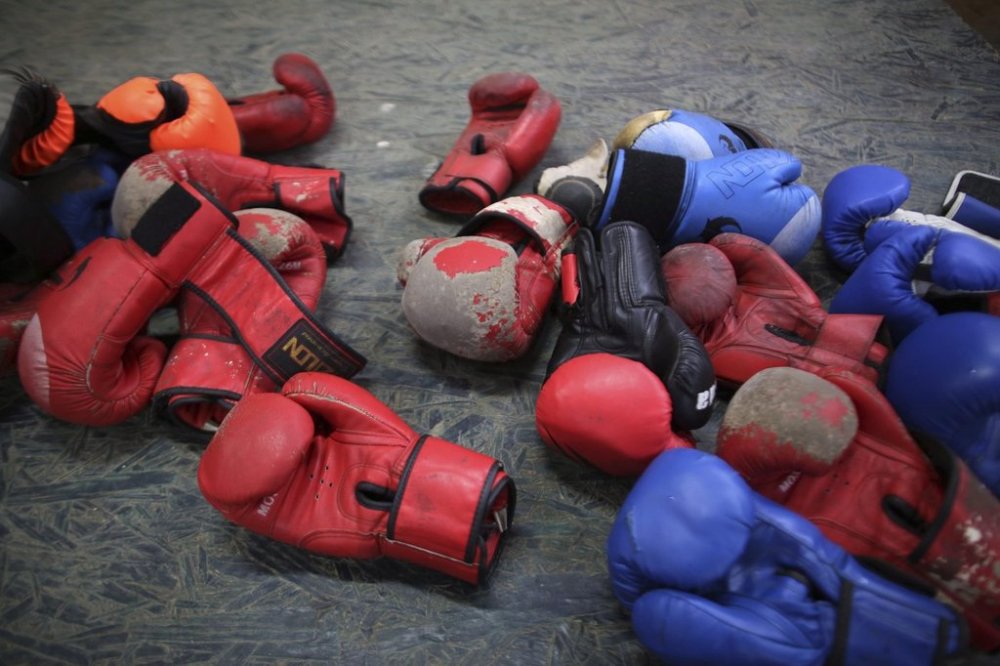 In this July 17, 2019 photo, old boxing gloves lay on the floor of a boxing gym in the Villa El Salvador shantytown in Lima, Peru. (AP Photo/Martin Mejia)