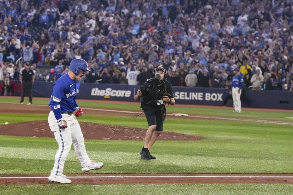 Toronto Blue Jays' Daulton Varsho (5) celebrates as he rounds third base after hitting a grand slam Boston Red Sox pitcher Justin Wilson during sixth inning MLB baseball action in Toronto on Thursday September 25, 2025. THE CANADIAN PRESS/Chris Young