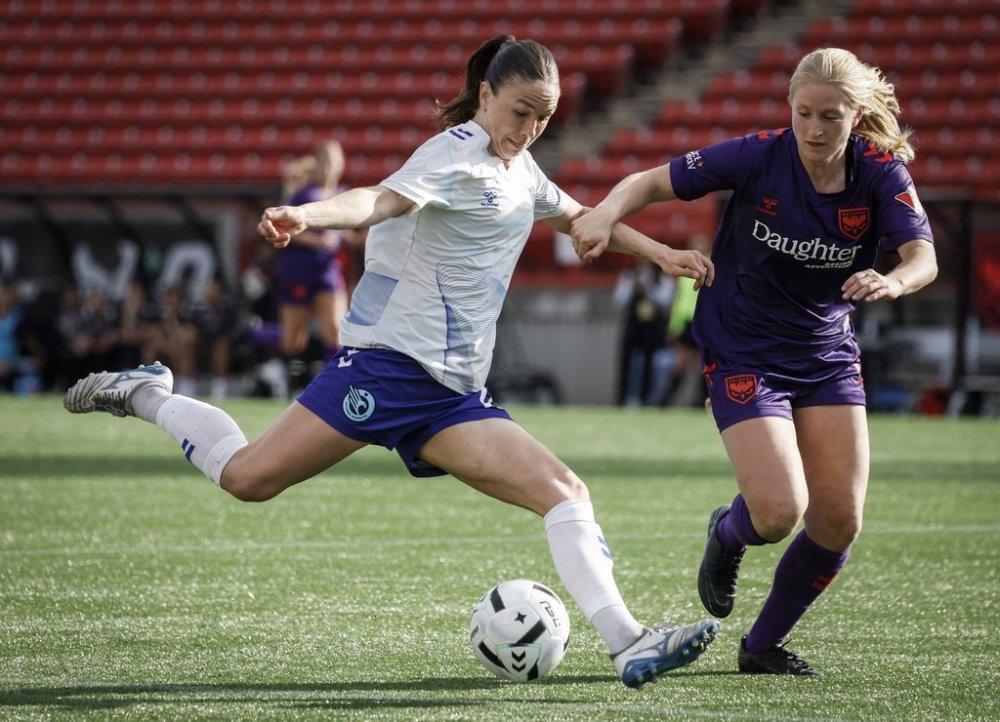Ottawa Rapid striker Delaney Pridham, left, kicks the ball as Mijke Roelfsema of the Wild closes in during Northern Super League play in Calgary on Sunday, May 11, 2025. THE CANADIAN PRESS/Jeff McIntosh
