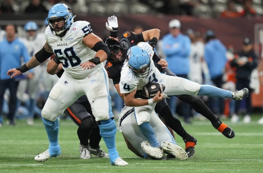 B.C. Lions' Mathieu Betts, back centre, sacks Toronto Argonauts quarterback Nick Arbuckle (4) behind Anthony Vandal (58) during the first half of a CFL football game, in Vancouver, on Friday, September 26, 2025. THE CANADIAN PRESS/Darryl Dyck