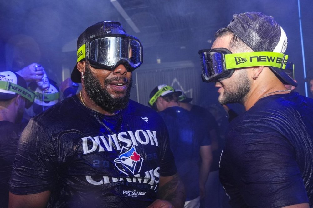 Toronto Blue Jays Vladimir Guerrero Jr. and Bo Bichette celebrate with teammates after winning the American League East Division title following MLB baseball action against the Tampa Bay Rays, in Toronto, Sunday, Sept. 28, 2025. THE CANADIAN PRESS/Chris Young