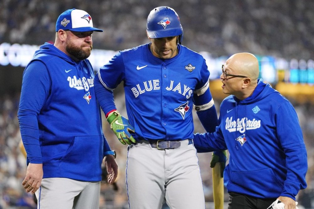 Toronto Blue Jays' George Springer (4) walks off the field as he leaves the game with an injury with manager John Schneider, left, and first assistant athletic trainer Voon Chong during seventh inning Game 3 World Series playoff MLB baseball action in Los Angeles on Monday, Oct. 27, 2025. THE CANADIAN PRESS/Frank Gunn