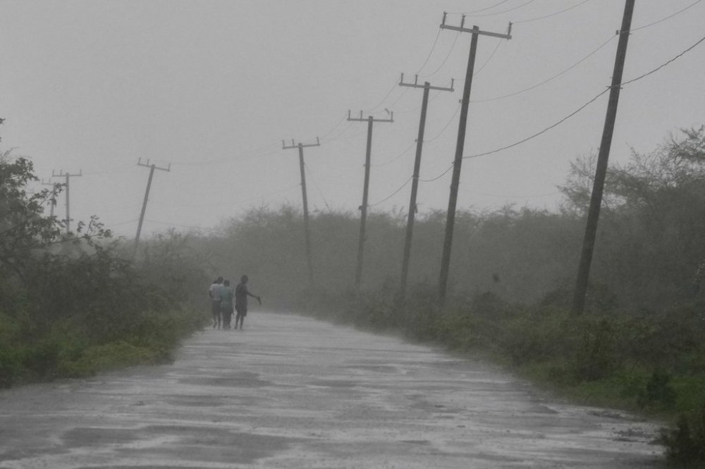 People walk along a road during the passing of Hurricane Melissa in Rocky Point, Jamaica, Tuesday, Oct. 28, 2025. (AP Photo/Matias Delacroix)