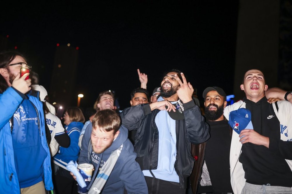 Baseball fans celebrate outside Rogers Centre following the Toronto Blue Jays World Series Game 1 win over the Los Angeles Dodgers in Toronto on Friday, October 24, 2025. THE CANADIAN PRESS/Nick Iwanyshyn