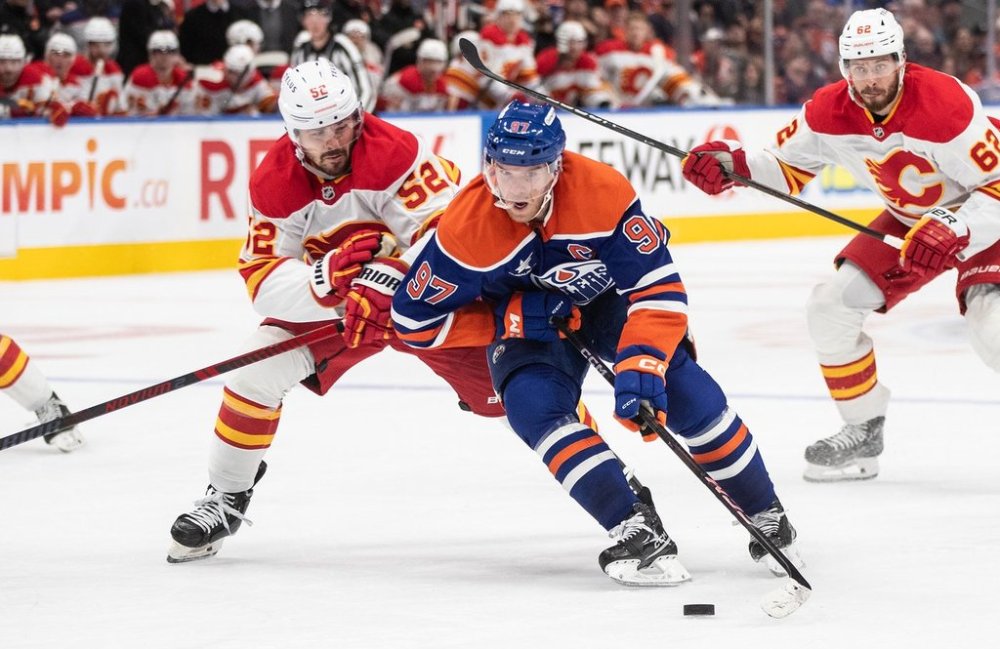 Calgary Flames' MacKenzie Weegar (52) chases Edmonton Oilers' Connor McDavid (97) during second period NHL action in Edmonton, Sunday, Oct. 13, 2024. THE CANADIAN PRESS/Jason Franson