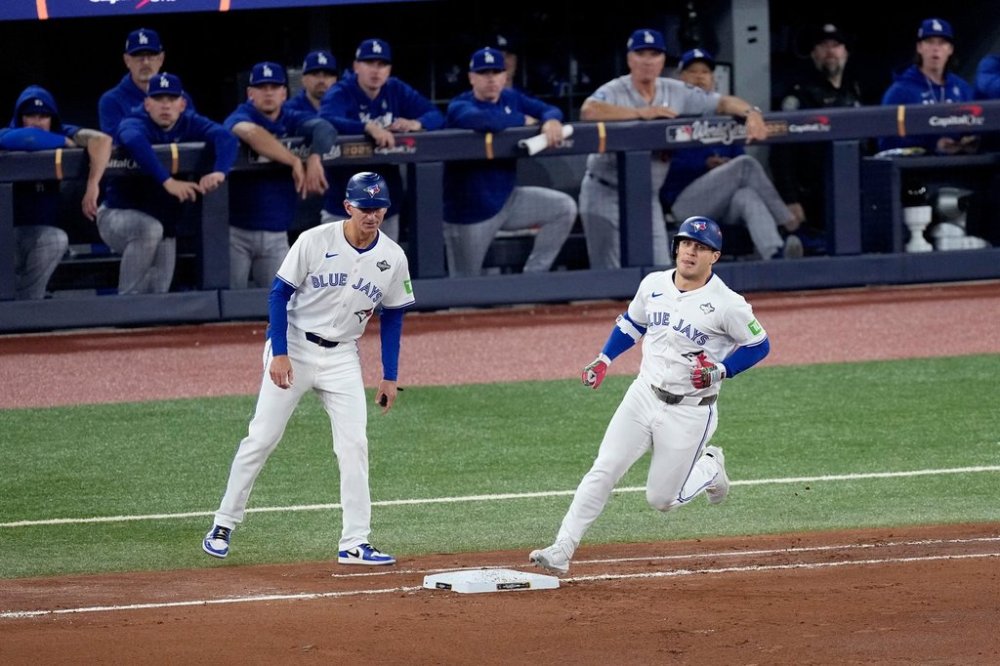 Toronto Blue Jays' Daulton Varsho runs past the Los Angeles Dodgers dugout after hitting his two run home run during the fourth inning in Game 1 of baseball's World Series, Friday, Oct. 24, 2025, in Toronto. (AP Photo/David J. Phillip)