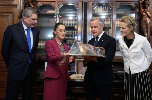 Jesus Maria Tarriba, left, and Diana Fox Carney, right, look on as Mexican President Claudia Sheinbaum presents a gift to Prime Minister Mark Carney at the National Palace in Mexico City on Thursday, Sept. 18, 2025. THE CANADIAN PRESS/Adrian Wyld