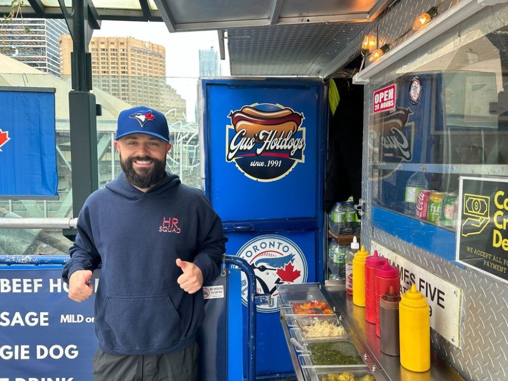 Johnny Prokos poses at his dad’s hotdog stand on the east side of Rogers Centre in Toronto, on Monday, Oct. 20, 2025. He describes the stadium as a second home to him and his dad and has been to over 500 games. THE CANADIAN PRESS/Cassidy McMackon