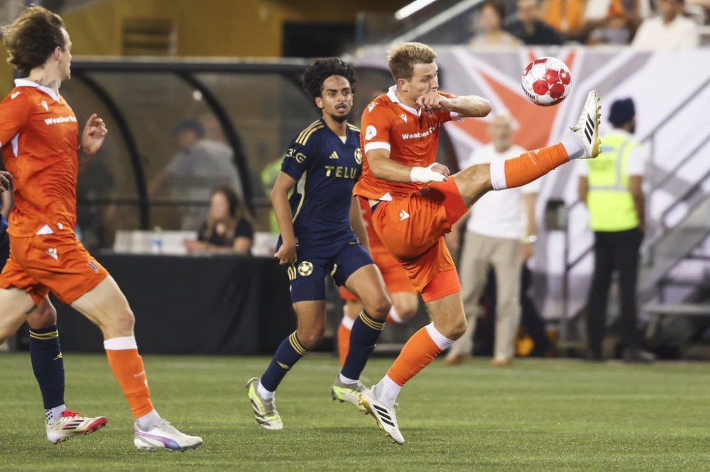 Forge FC's Daniel Nimick (right) tries to settle down a ball with pressure from Vancouver Whitecaps' Jeevan Singh Badwal (59) during second half Canadian Championship semifinal soccer action in Hamilton, on Thursday, August 13, 2025. THE CANADIAN PRESS/Nick Iwanyshyn