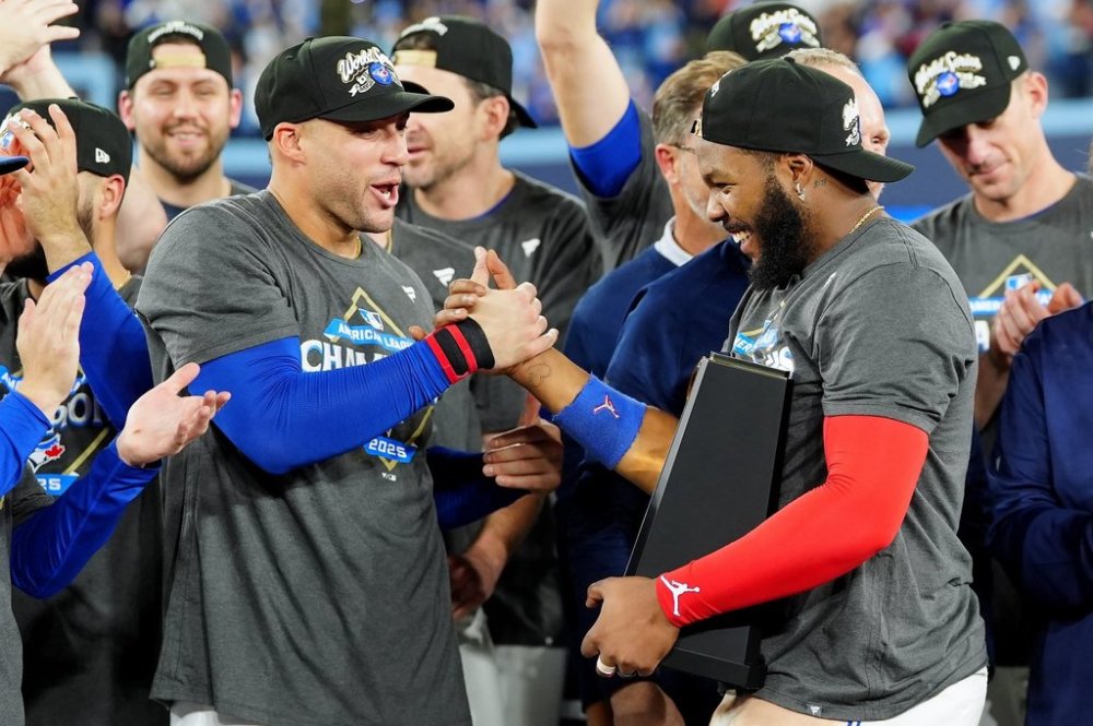 Blue Jays designated hitter George Springer and teammate Vladimir Guerrero Jr. celebrate after defeating the Seattle Mariners 4-3 in Game 7 of the MLB American League Championship Series in Toronto on Oct. 20, 2025. THE CANADIAN PRESS/Frank Gunn