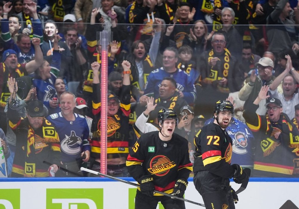 Vancouver Canucks' Filip Chytil (72) and Elias Pettersson (25) celebrate Chytil's goal against the Calgary Flames during the third period of an NHL hockey game in Vancouver, on Thursday, October 9, 2025. THE CANADIAN PRESS/Darryl Dyck