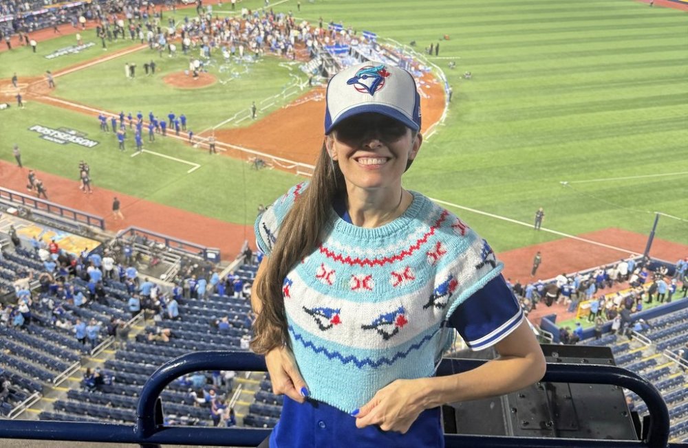 Karla Courtney is shown wearing the Toronto Blue Jays-themed sweater she's knitting during the playoff run as the Blue Jays celebrate their ALCS victory in Toronto in this Monday, Oct. 20, 2025 handout photo. THE CANADIAN PRESS/Handout - Karla Courtney (Mandatory Credit)