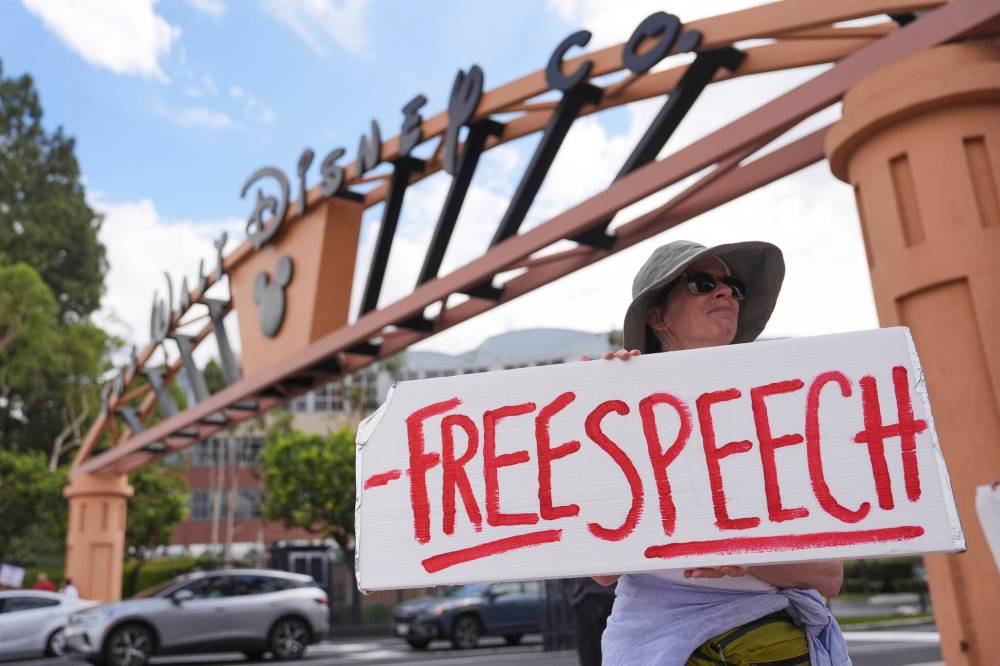 A protester holds a sign in response to the suspension of Jimmy Kimmel’s late-night show outside of Walt Disney Studios in Burbank, Calif., on Sept. 18. Kimmel was back on the air Sept. 23. (The Associated Press files)