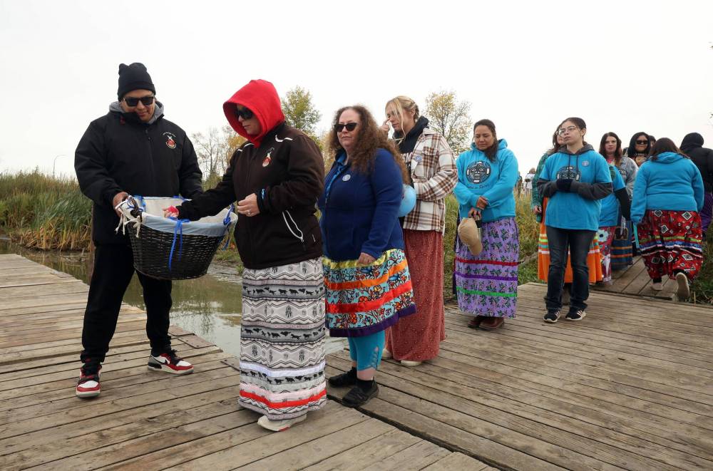 Participants take flower petals and tobacco to place in the Assiniboine River in honour and remembrance of missing and murdered Indigenous women and girls during last year’s Sisters In Spirit petal ceremony. This year’s petal ceremony takes place Saturday morning, followed by a free bannock breakfast sandwich at the Brandon Riverbank. (Tim Smith/The Brandon Sun files)