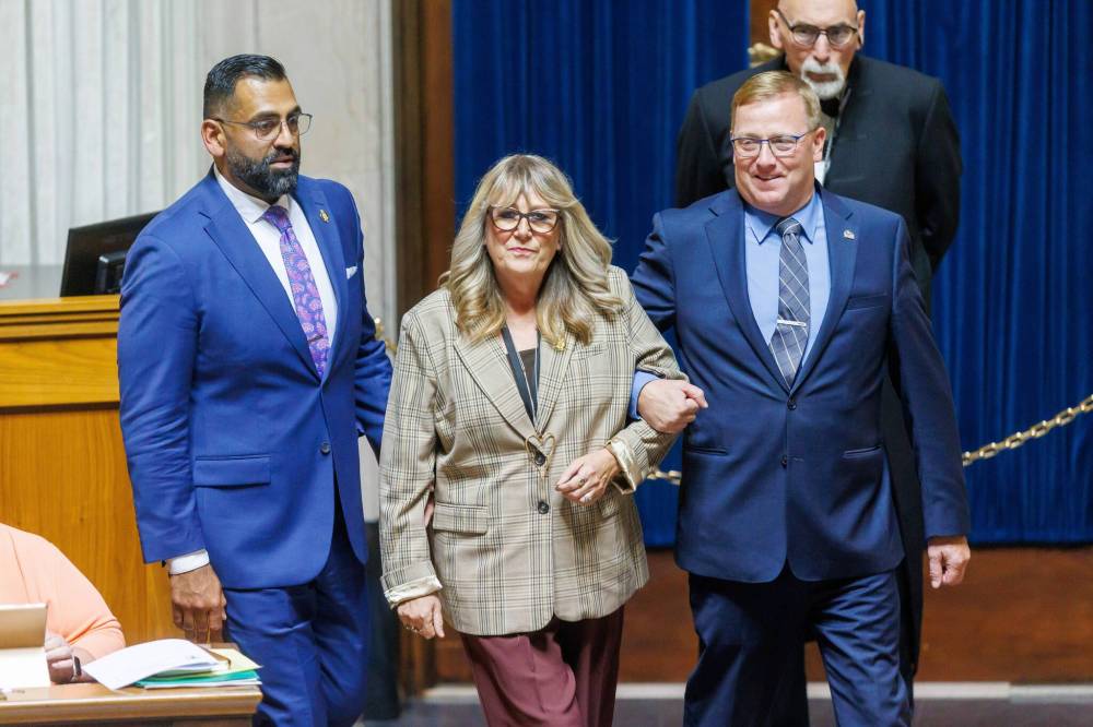 Newly elected PC MLA Colleen Robbins (Spruce Woods) is led to the Speaker for the traditional introduction by the PC House leader, MLA Derek Johnson (right), and PC party Leader Obby Khan (left) on her first question period during the first day of the second session of the 43rd legislature on Wednesday afternoon. (Mike Deal/Winnipeg Free Press)