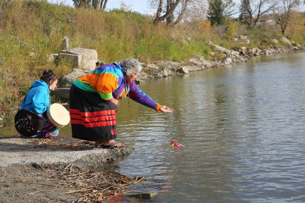 Debbie Kuehne tosses petals into the Assiniboine River as part of the Sisters in Spirit petal ceremony at the Riverbank Discovery Centre on Saturday. The ceremony was to honour missing and murdered Indigenous women and girls. (Photos by Alex Lambert/The Brandon Sun)