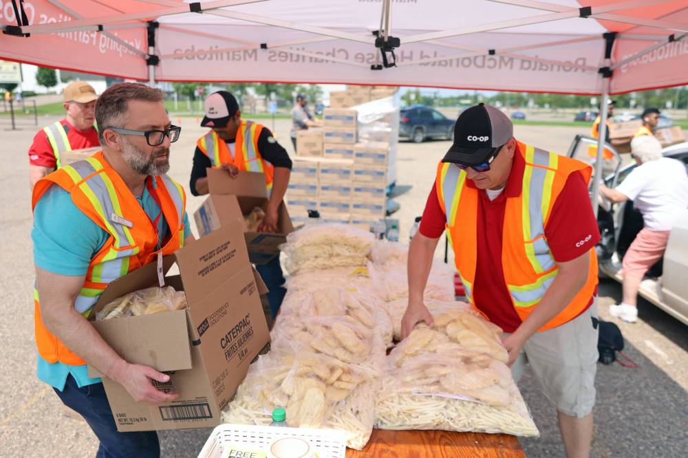 Volunteers grab bags of frozen fries and hashbrowns to hand out in exchange for donations during a McCain French Fry Day fundraiser last year. This year’s event takes place on the Keystone Centre grounds today from 10 a.m. to 4 p.m., with proceeds going to Ronald McDonald House Charities Manitoba. (Colin Slark/The Brandon Sun files)
