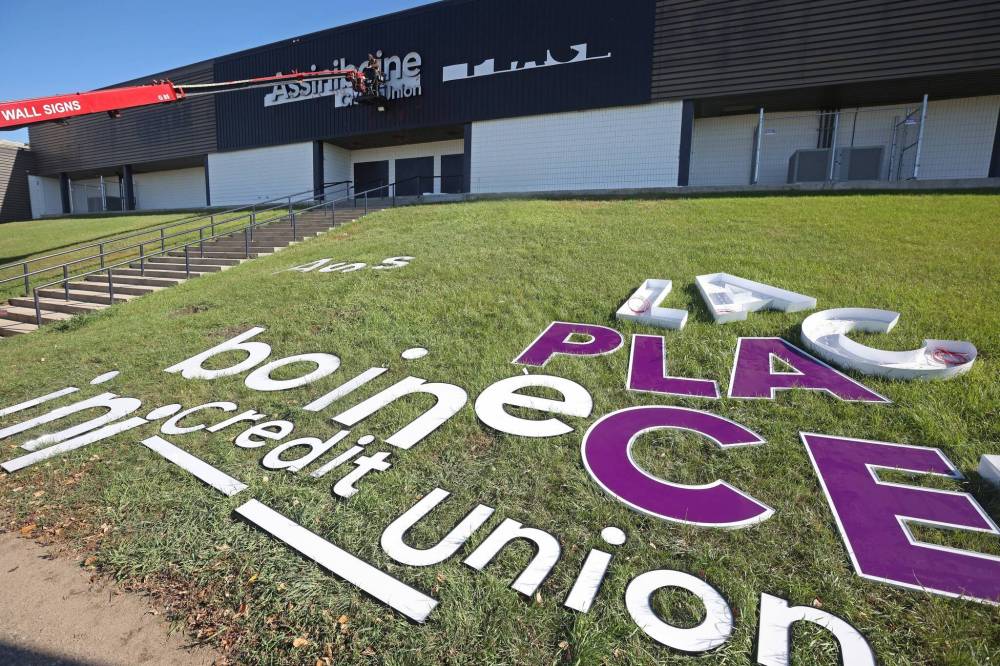 A worker with Off The Wall Signs installs the new lettering for Assiniboine Credit Union Place on the west side of the arena on Tuesday. (Tim Smith/The Brandon Sun)