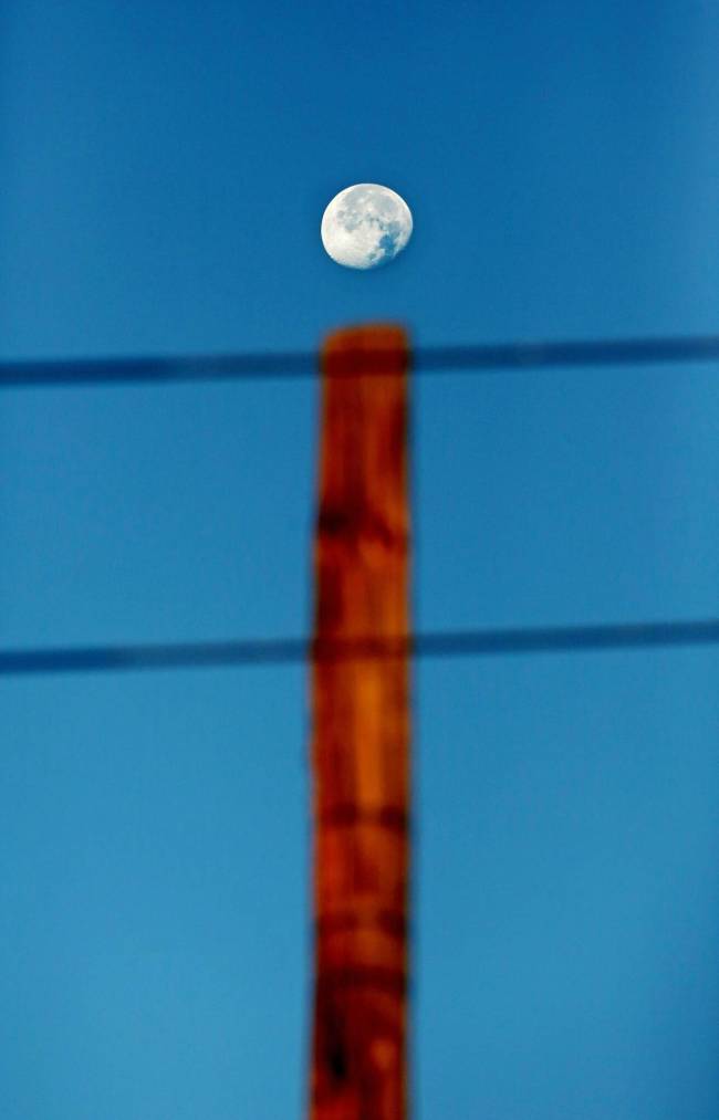 A waning moon dots the ‘I’ of a hydro pole in downtown Brandon early Thursday morning. (Matt Goerzen/The Brandon Sun)