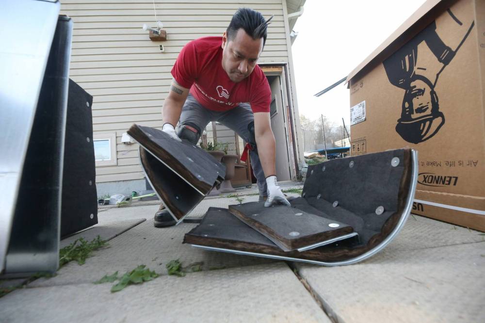 Alexy Hernandez, a sheet metal worker with Brandon Heating and Plumbing, pulls together pieces of a new Lennox furnace being installed as part of a giveaway program to a family on Stickney Avenue on Tuesday morning. (Matt Goerzen/The Brandon Sun)