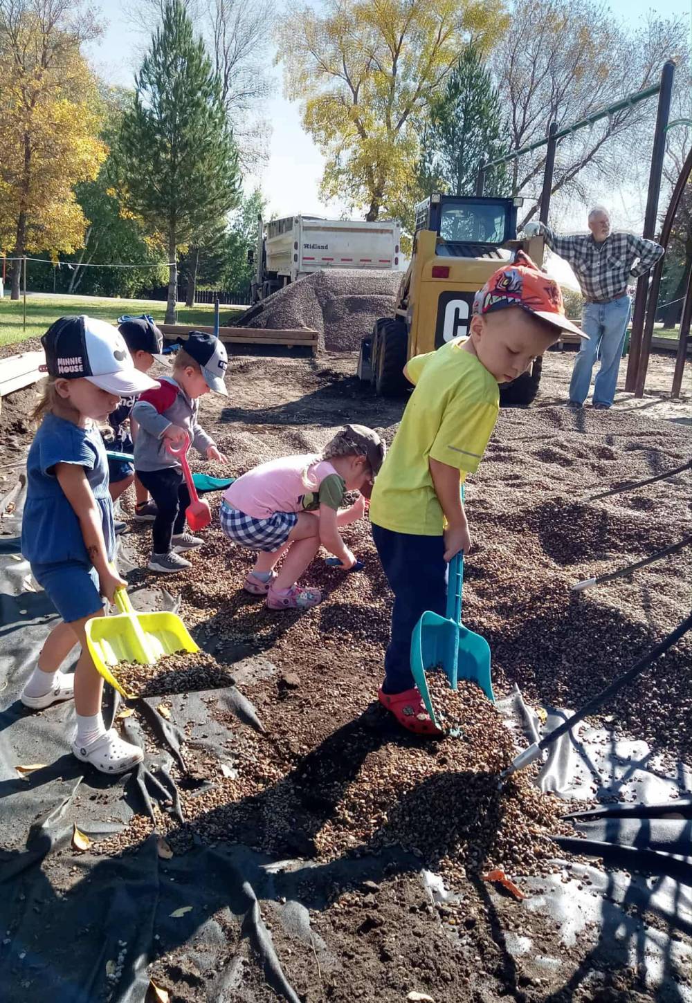 Kids were part of the installation process for the new Kenton playground, seen here to be piling gravel into the play structure base. (Virden Empire Advance)