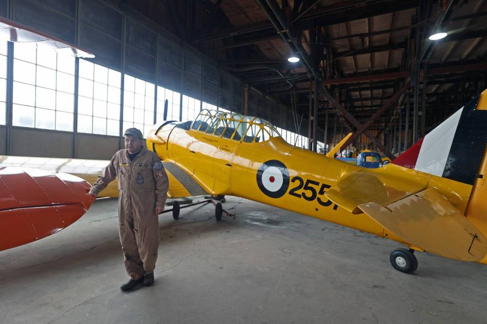 Jeff Bell stands before a yellow Harvard MkII aircraft in the hangar of the Commonwealth Air Training Plan Museum in Brandon in October. Bell flies the aircraft the most of all antique aircraft stored at the museum. (Connor McDowell/The Brandon Sun)