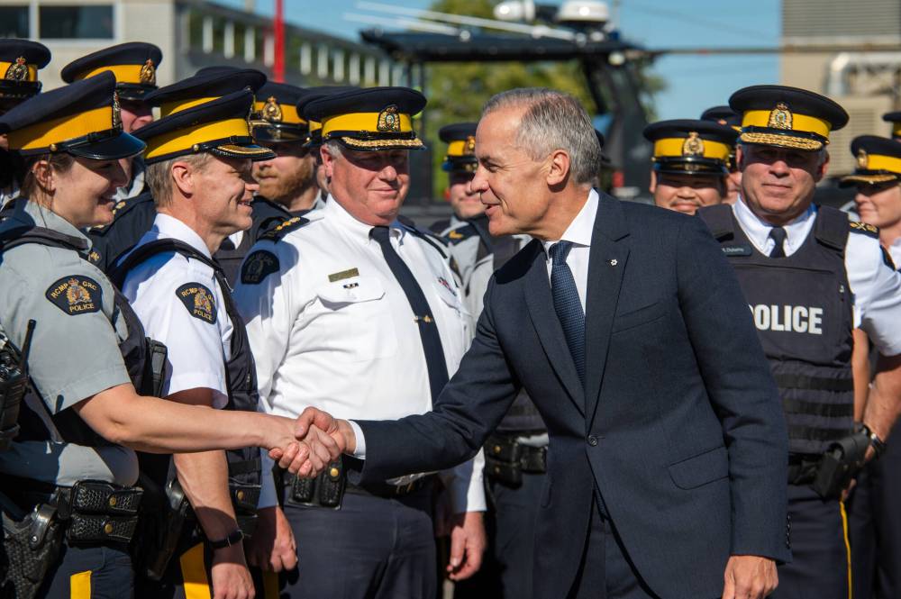 Prime Minister Mark Carney visits an RCMP detachment to make an announcement in Etobicoke, Ont., on Thursday. (The Canadian Press)