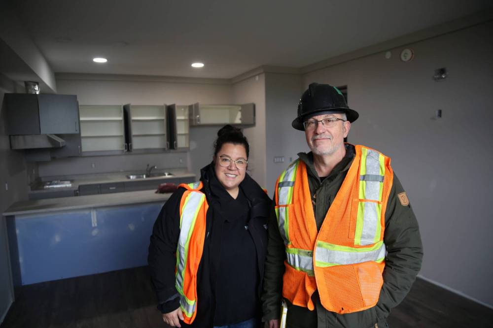 Shannon Saltarelli, the City of Brandon’s community housing and wellness co-ordinator, and Robinson stand inside the living space of a suite at the transitional housing facility on 16th Street North in Brandon on Friday. A full kitchen is being installed behind them. It is one of the eight large suites on the third floor of the facility that also includes a bedroom and a full bathroom. (Connor McDowell/The Brandon Sun)