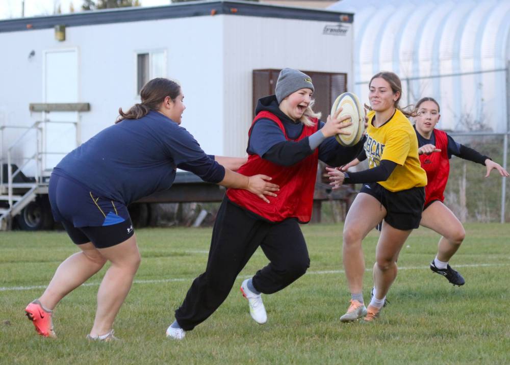 Brandon University rugby captain Breanna Sakal splits a pair of defenders with the ball during practice at John Reilly Field on Wednesday. (Thomas Friesen/The Brandon Sun)