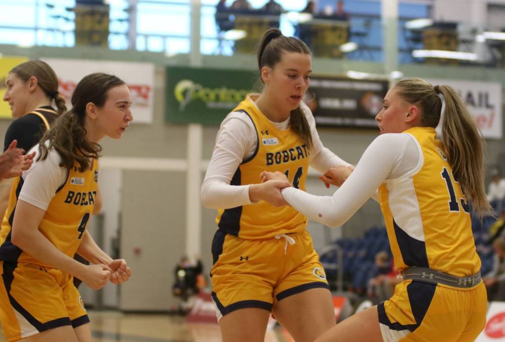 Brandon University’s Renee Dauphinais helps Ella Averill up after an and-one against the Manitoba Bisons during their Canada West women’s basketball season opener at the Healthy Living Centre on Friday. (Thomas Friesen/The Brandon Sun)