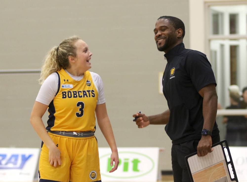 Brandon University guard Piper Ingalls and coach Ilarion Bonhomme share a laugh late in the fourth quarter of their Canada West women’s basketball season opener on Friday. (Thomas Friesen/The Brandon Sun)