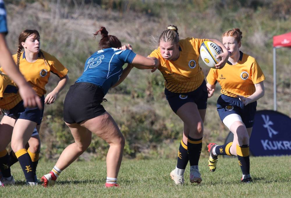 Brandon University's Beth Couling stiff-arms a Mount Royal defender during their Prairie University Women' Rugby Conference semifinal at John Reilly Field on Friday. (Thomas Friesen/The Brandon Sun)