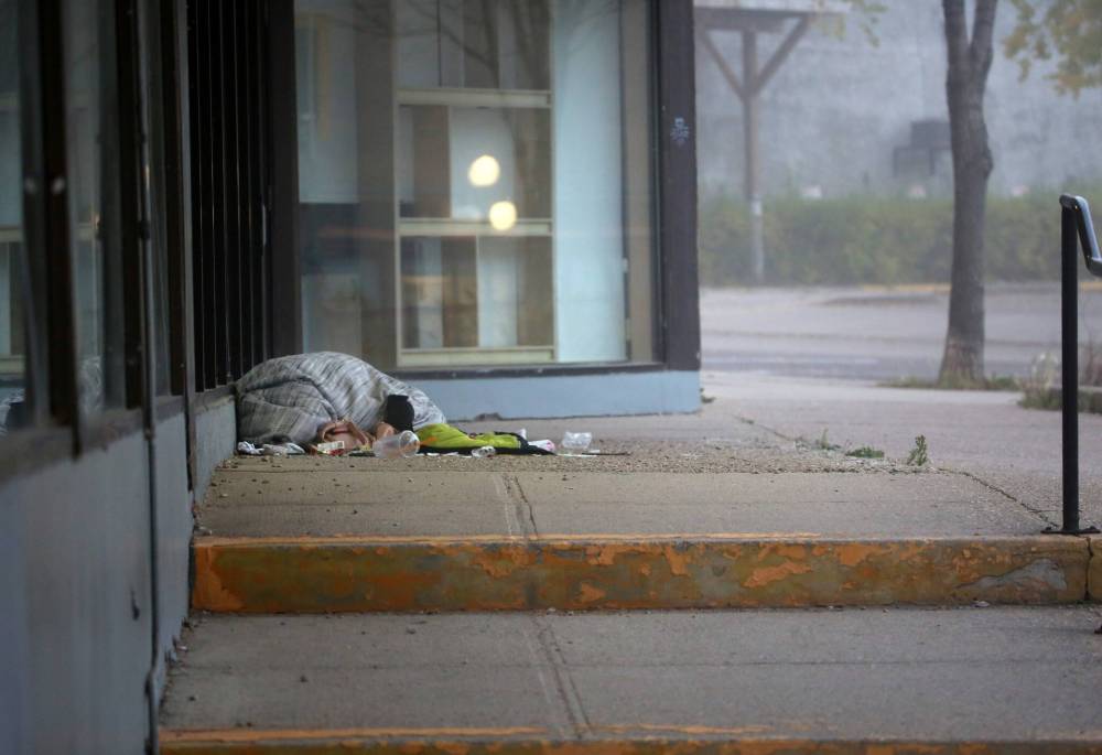 A homeless person lying on the sidewalk outside The Town Centre attempts to keep out the cold air with a blanket on a Thursday morning when the temperature fell to -4 C. (Matt Goerzen/The Brandon Sun)