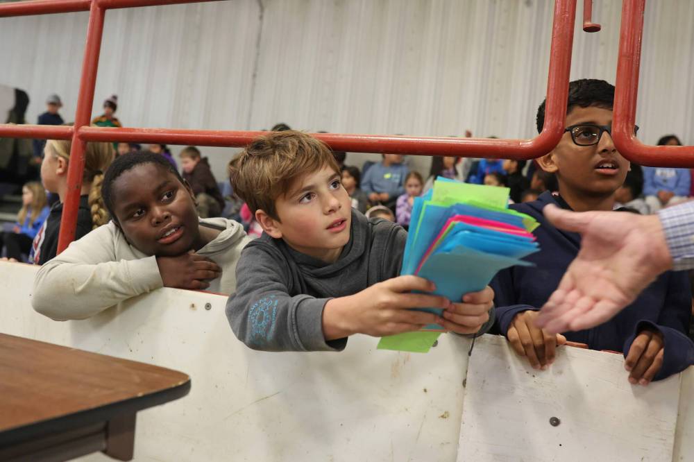 Elementary school students bid on cattle during a pretend cattle auction. (Tim Smith/The Brandon Sun)