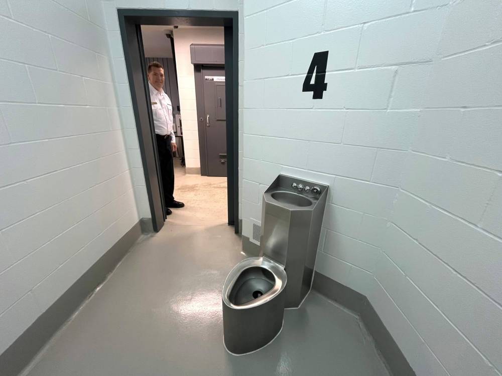 Brandon police Chief Tyler Bates looks in the door of a holding cell at the recently constructed police detention facility at BPS headquarters on Victoria Avenue and 10th Street. Cells are small, holding a urinal and wash basin, as well as a mattress. (Matt Goerzen/The Brandon Sun)
