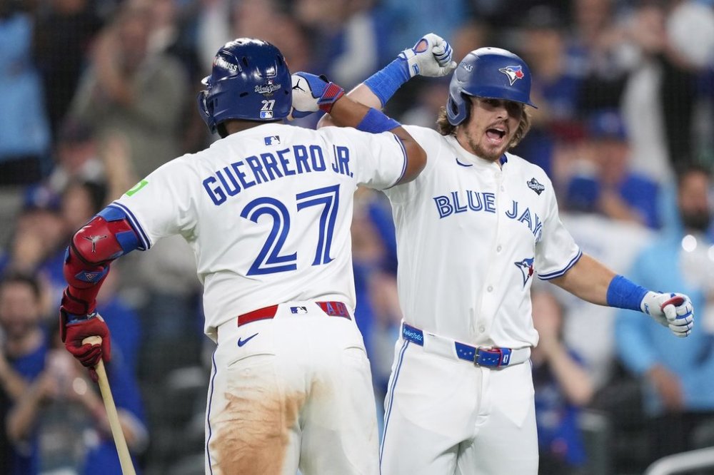 Toronto Blue Jays' Addison Barger, right, celebrates after hitting a grand slam with Vladimir Guerrero Jr. during sixth inning Game 1 World Series playoff MLB baseball action against the Los Angeles Dodgers in Toronto on Friday, Oct. 24, 2025. THE CANADIAN PRESS/Nathan Denette