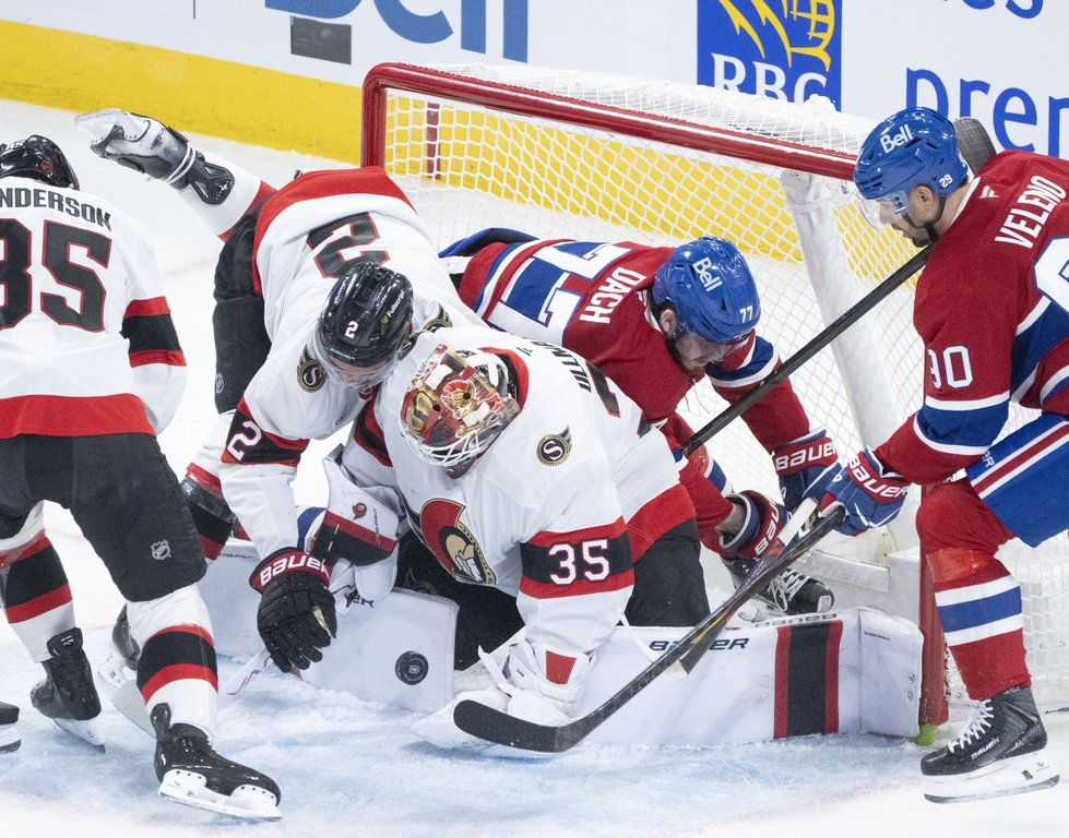 Ottawa Senators goaltender Linus Ullmark (35) stops a shot as Montreal Canadiens' Kirby Dach (77) is tripped into the net by Senators' Artem Zub (2) during second period NHL hockey action in Montreal on Saturday, Nov. 1, 2025. THE CANADIAN PRESS/Christinne Muschi